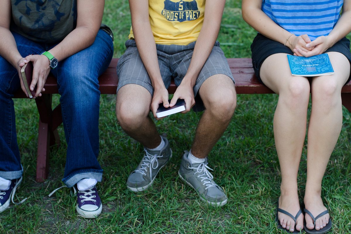 Group of friends sitting on park bench